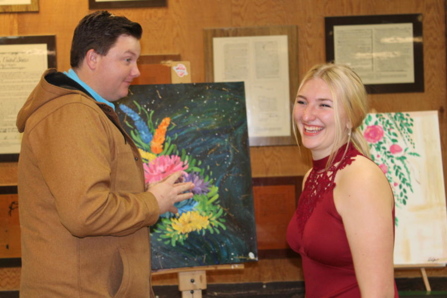 Senior Andrea Gieser displaying her artwork at the Art Gala