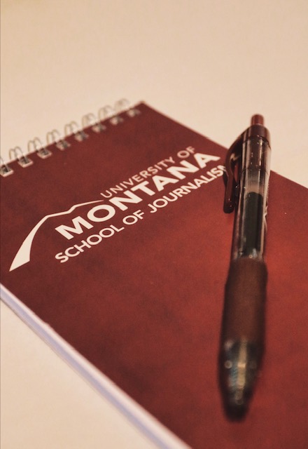 A pen and a notebook, courtesy of the University of Montana, await further use.