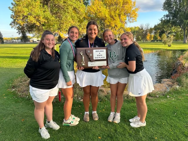 The girls golf team taking a picture with the second place trophy 