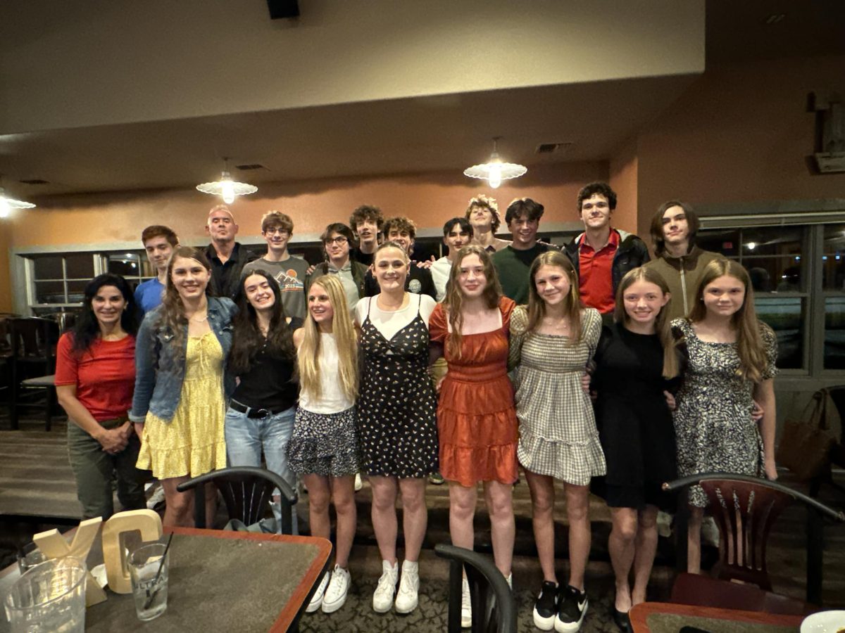 11.28.23 Cross Country Team poses for a photo together following their team banquet at the Red Door  