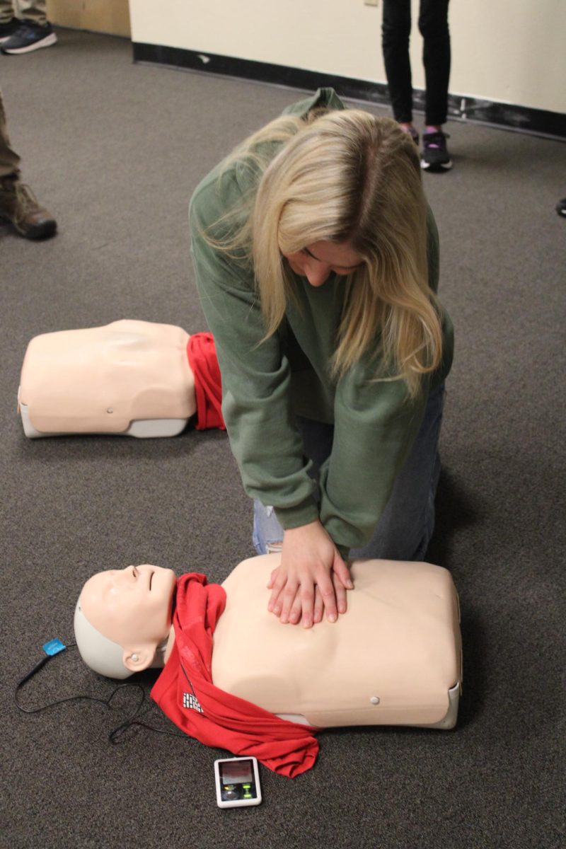 10.12.23 Junior Courtney Hofer practices CPR on a test dummy during first aid training. 