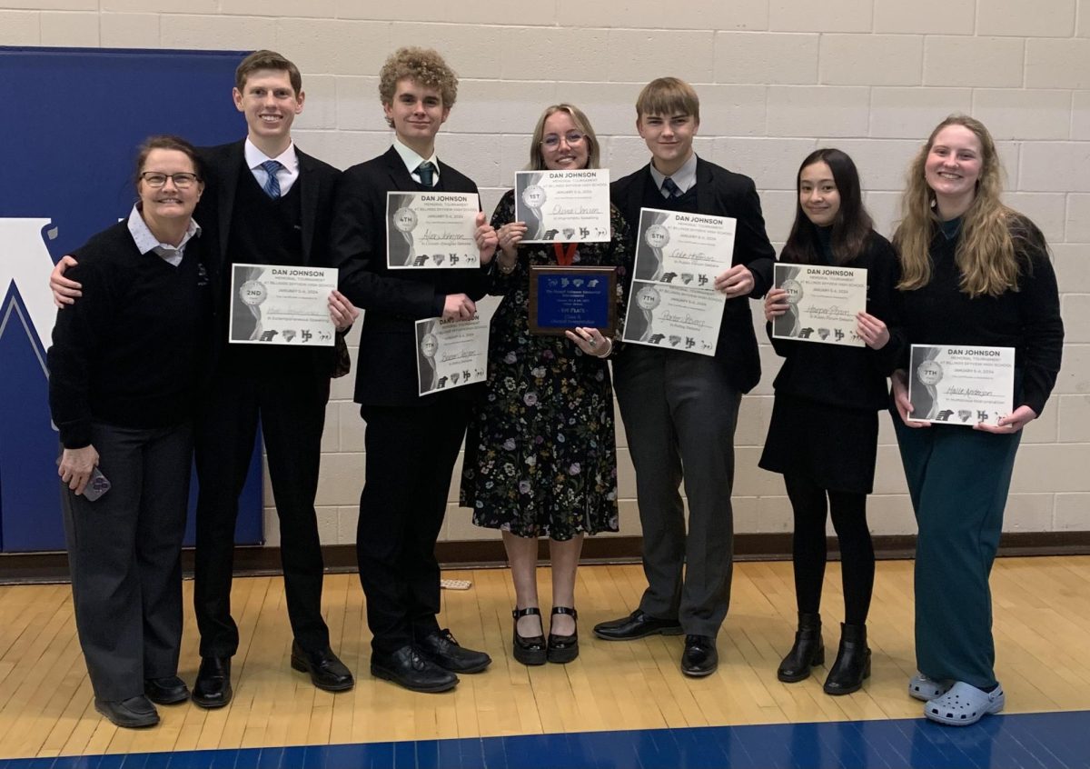 01.06.2024 Speech and Debate students along with coach, Pam Muskett(far left), pose with their individual certificates along with the 1st place speech plaque at Skyviews Speech, Drama, and Debate tournament. 