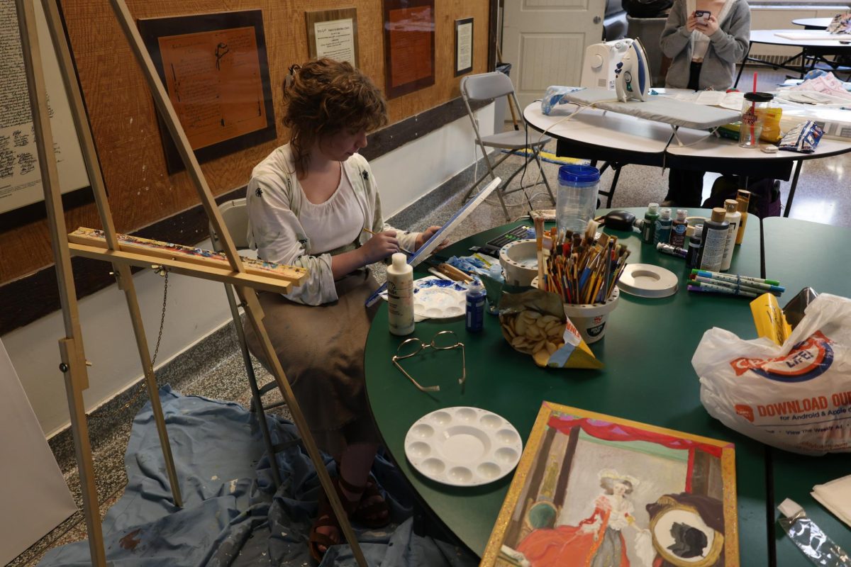 Zoie Weston paints the first of two paintings in the Central cafeteria at the 24-Hour Art Challenge on Dec. 21, 2023.