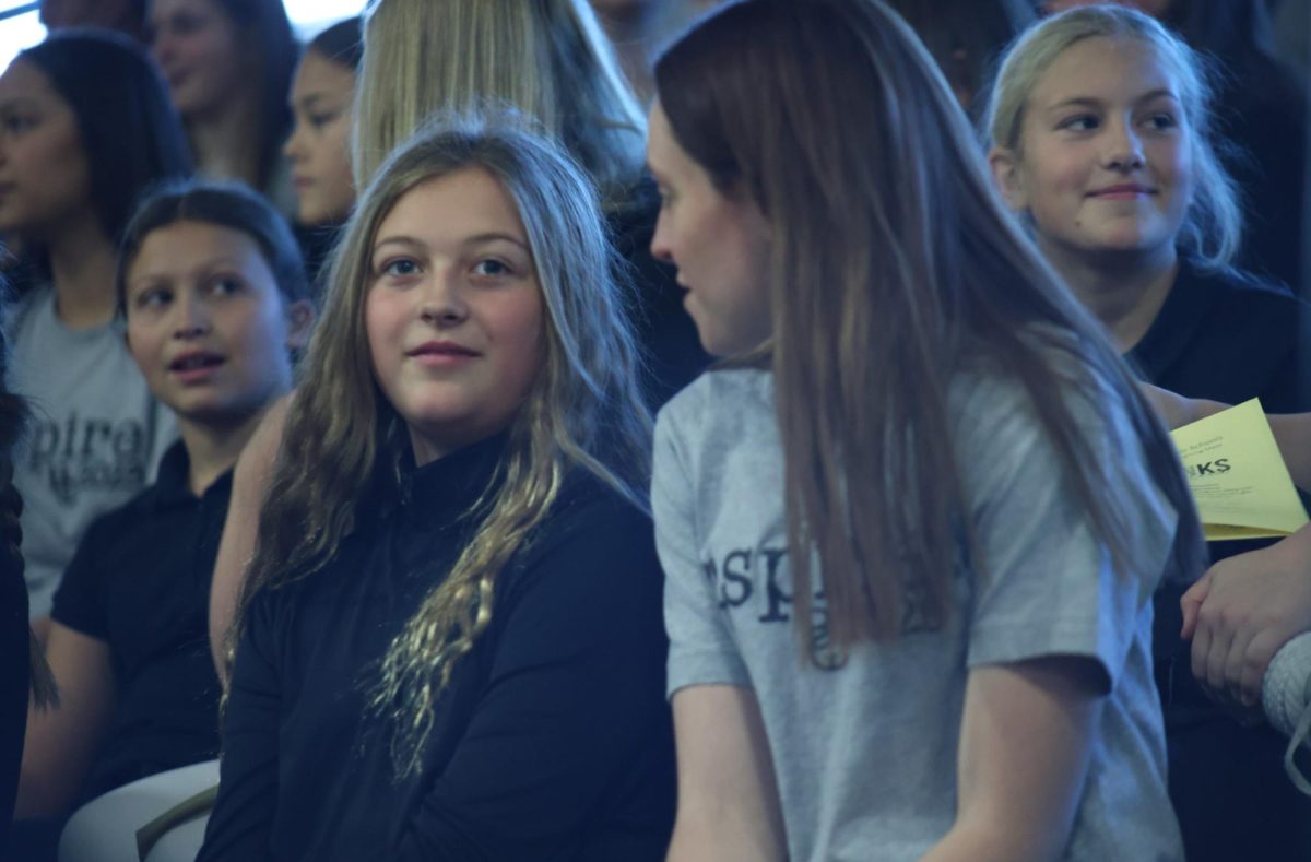 Junior Samantha Day talks with her KCK buddy, Fynnly Dyk at All System Mass on Nov. 21, 2023