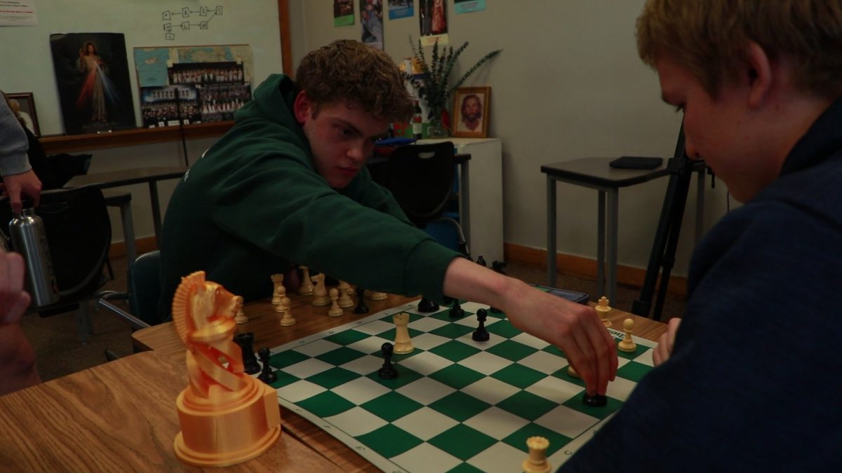 3.6.2024 Junior Dylan Shelton moving a chess piece in the championship match. 