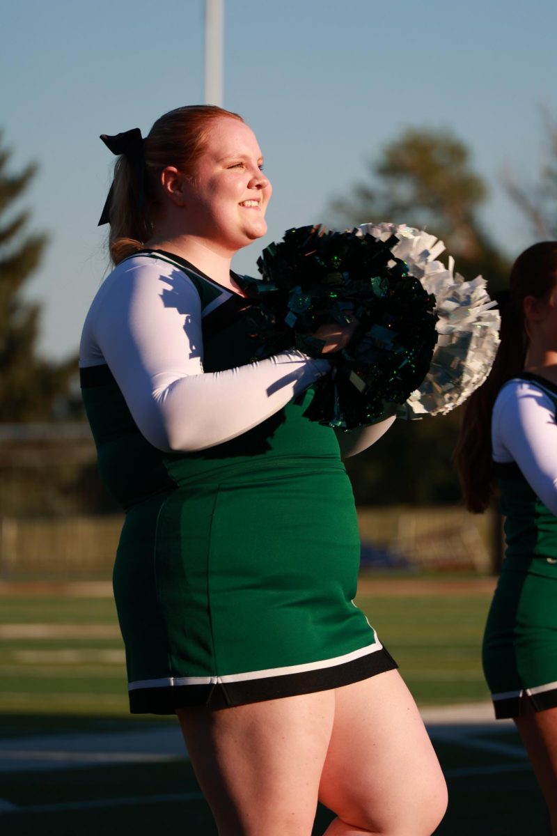 8.30.24 Senior cheerleader, Madi Gibson, smiling towards the crowd as he cheers for the first home football game.