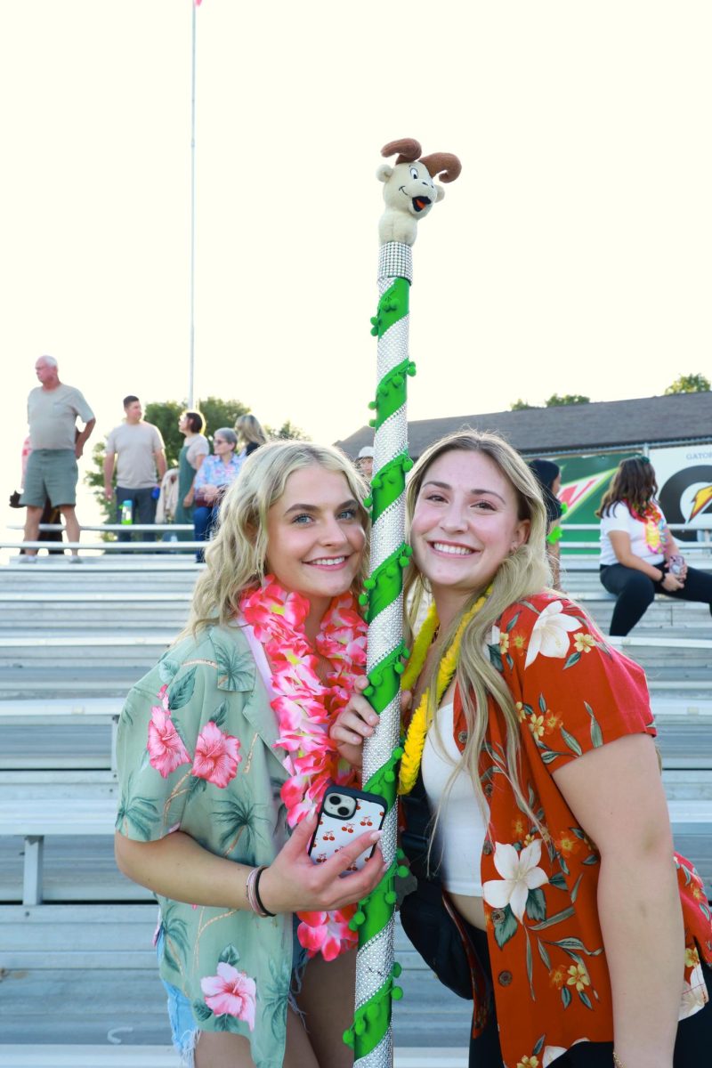 8.30.24 (From L to R) Seniors Courtney Hofer and Emirie Hastings holding the Spirit Stick at the Friday night Rams vs Red Devils football game.