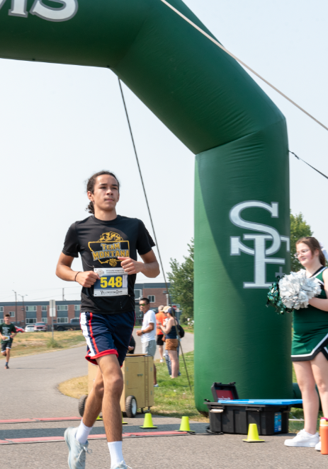 9.8.24 Junior Aramis Rivera runs through the finish line at Running on Faith. 