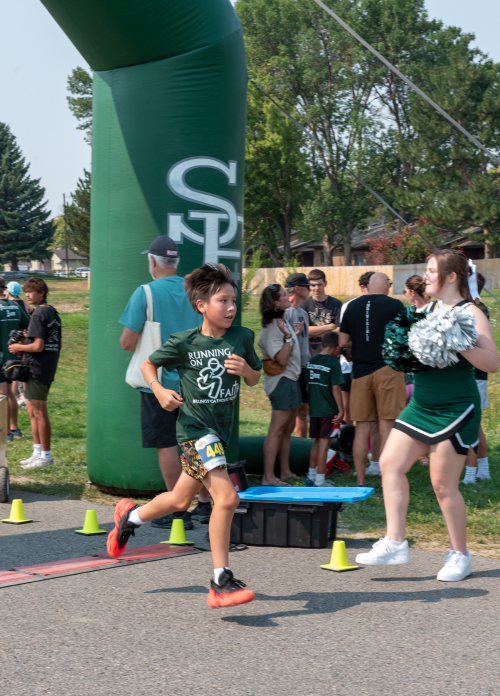 9.8.24 6th Grade John W Turnsplenty runs through the finish line. 