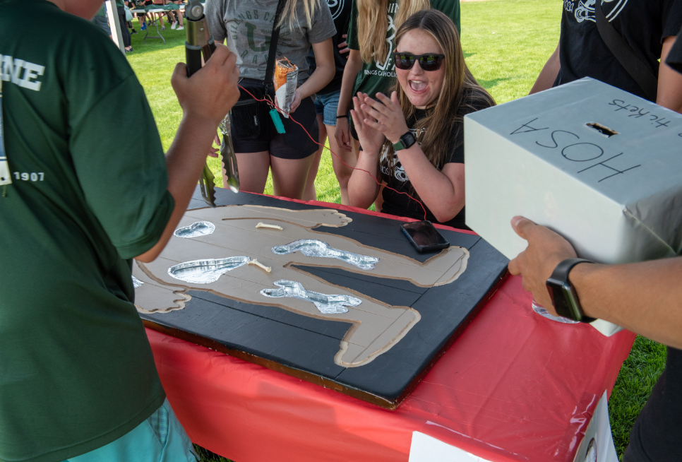 9.8.24 HOSA Vice President Ella  Fairbanks cheers on the players of the life size operation game at Running on Faith. 