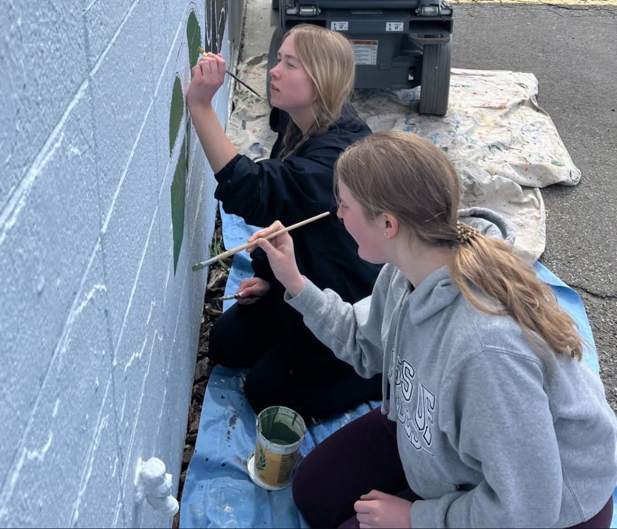 (From L to R) Seniors Kelly Early and Halle Anderson helping with painting the mural. 