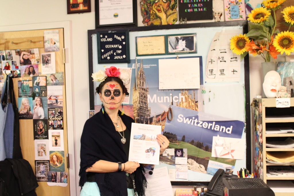 10.31.25 Group leader for the Munich/Switzerland trip and Central Art teacher Kari Adams holds up a flyer for her trip. 