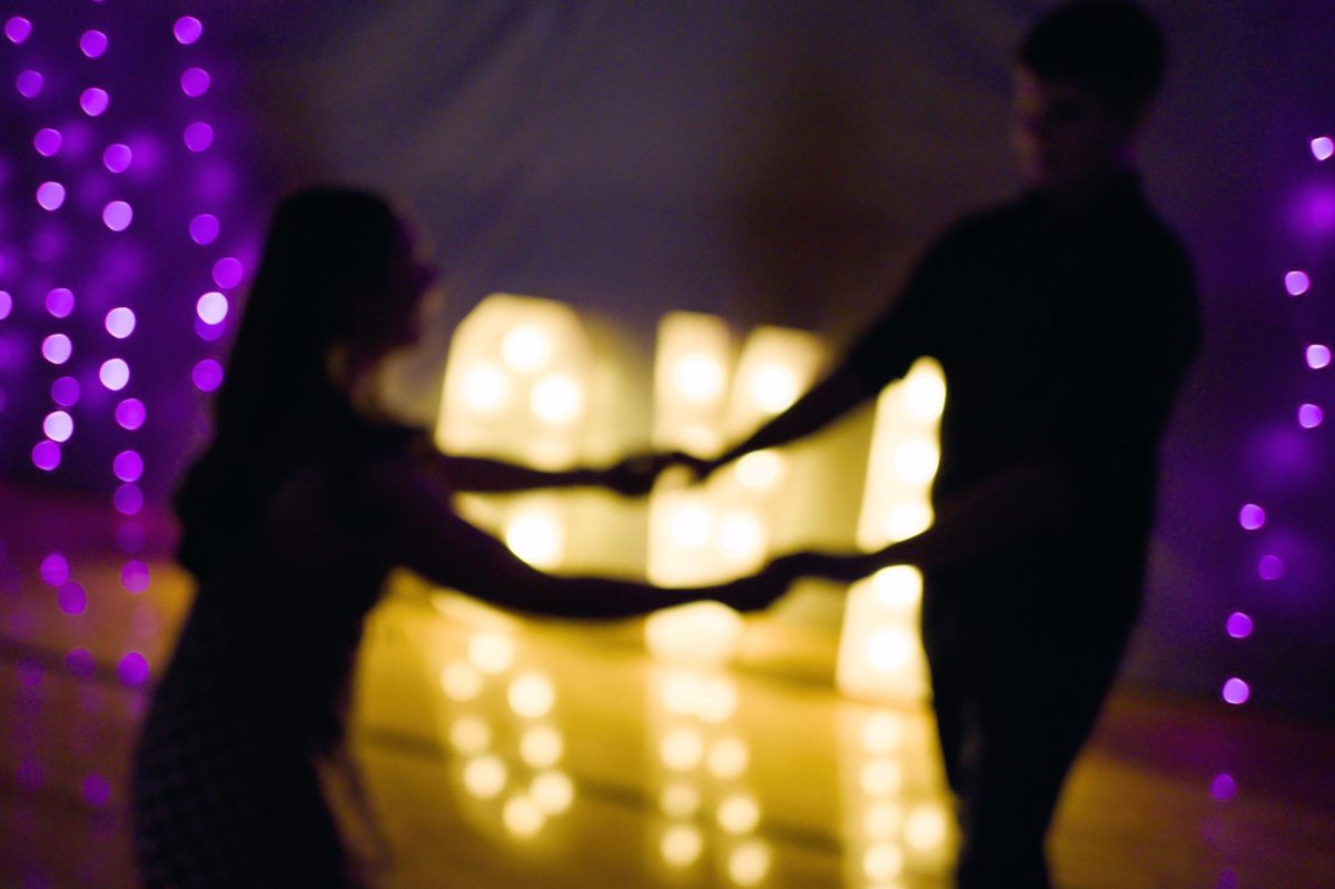 2.7.26. A look at two central students slow dancing in front of the love sign.