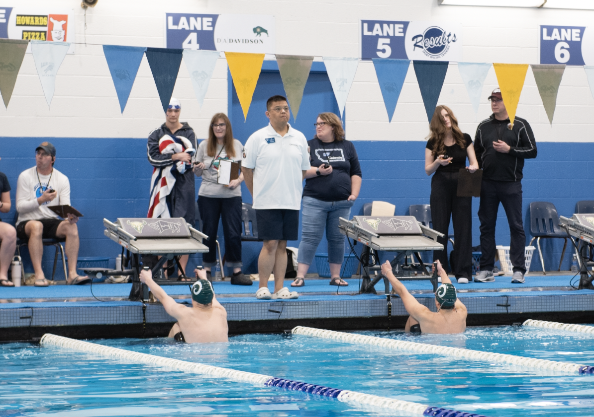 2.14.26 
(Left to Right) Junior Jonas Johnson and Sophomore Ethan Shaub place their feet before the start of the Boys 100 Backstroke Finals. 