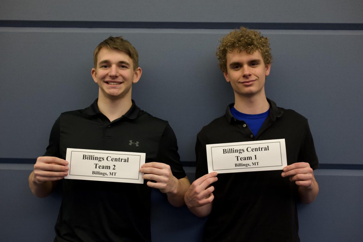 (From L to R) Seniors and team captains Nethanel Keener and Alex Johnson pose for a photo with their team signs. 